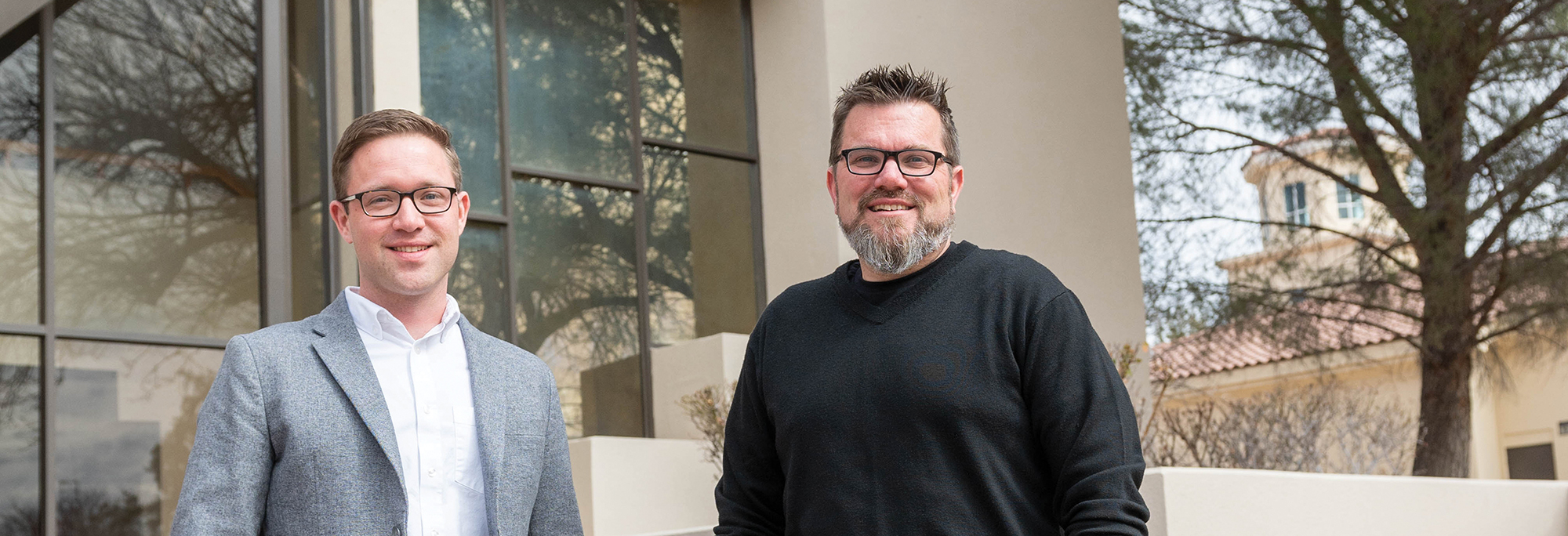 Two professors standing in front of music center.