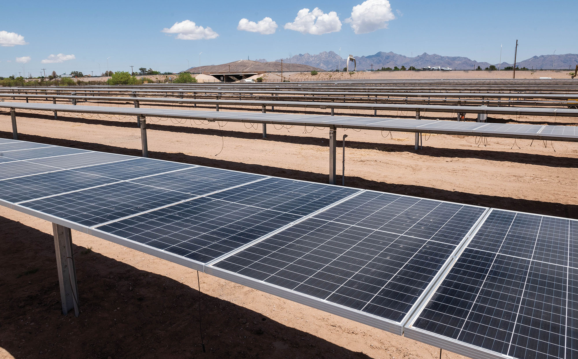 Rows of solar panels with mountains in the distance