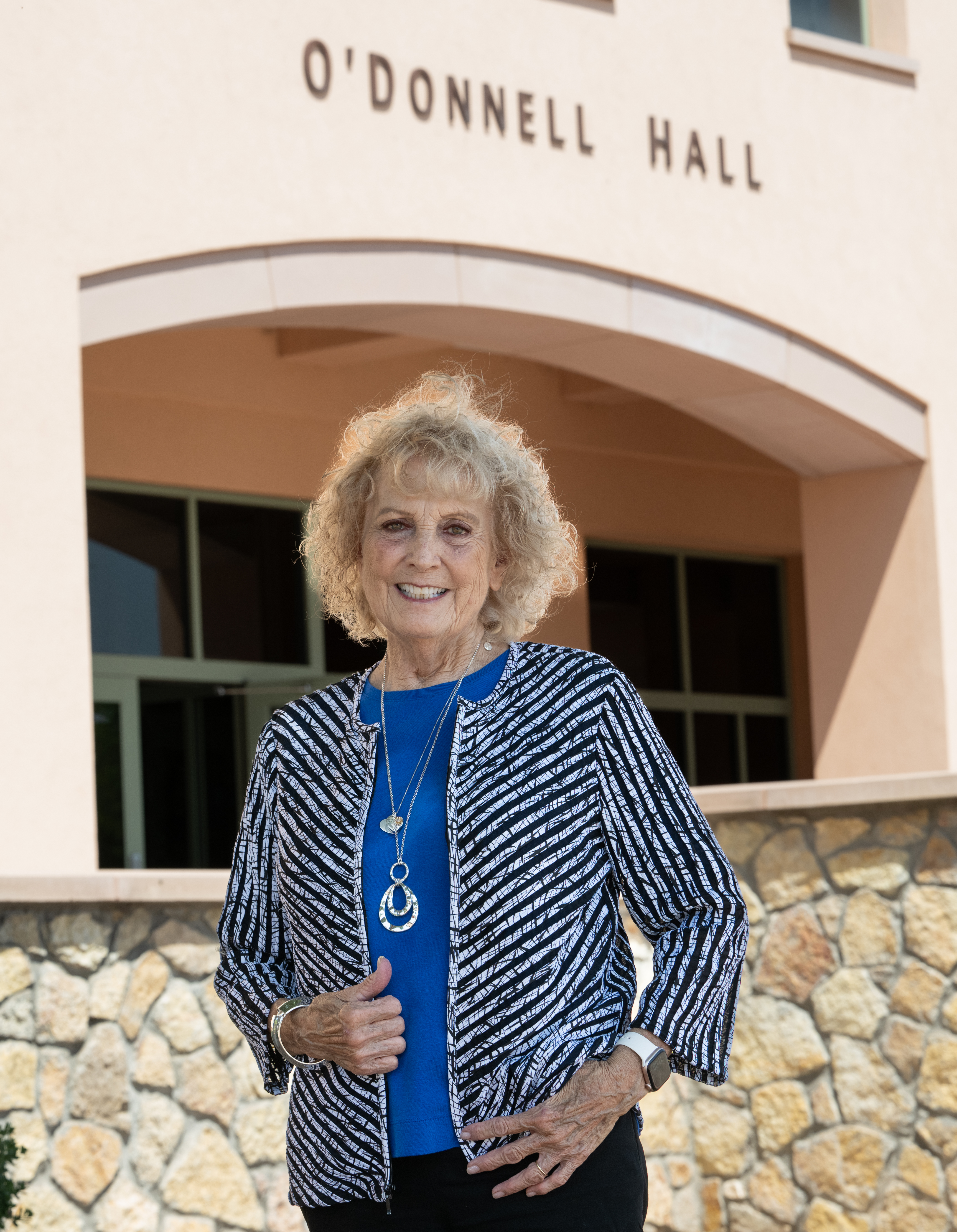 woman standing outside building smiling for photo